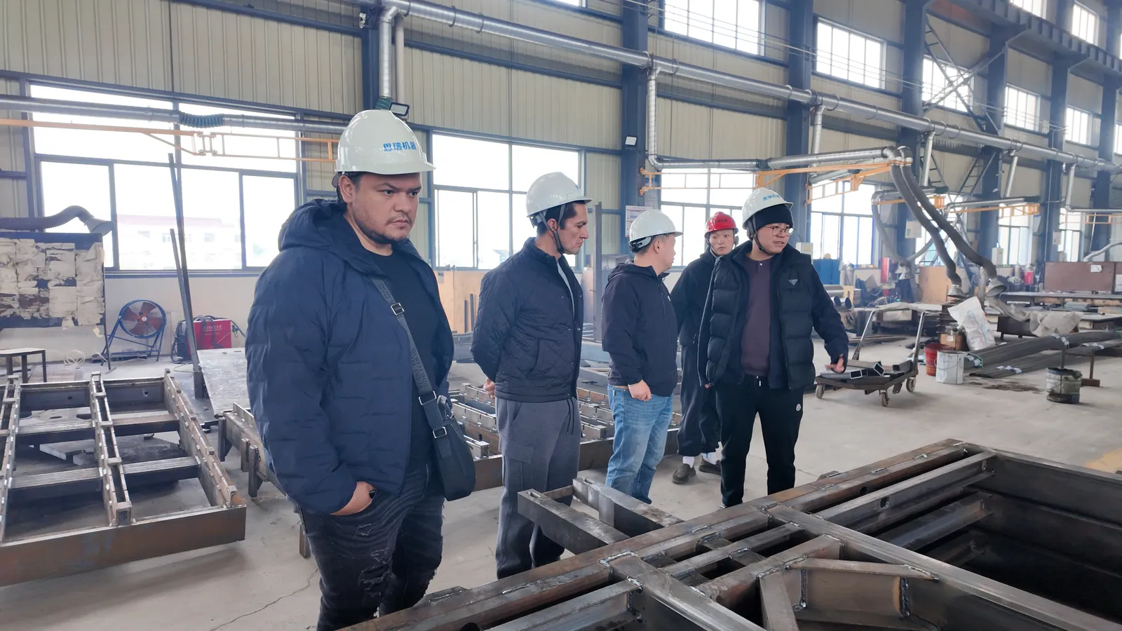 Machine frames in fabrication at SREE, seen by Mexican visitors